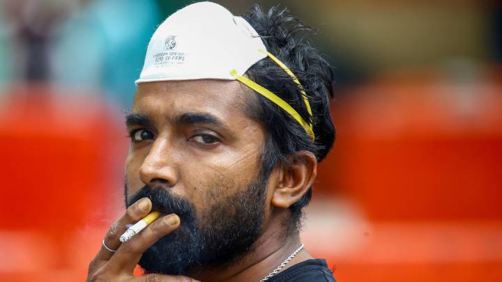 Un hombre con una mascarilla N95 fuma en Singapur. 