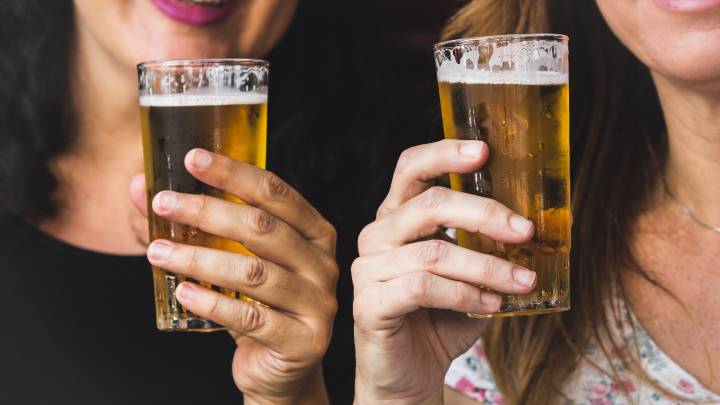 Dos mujeres brindan con cerveza. 