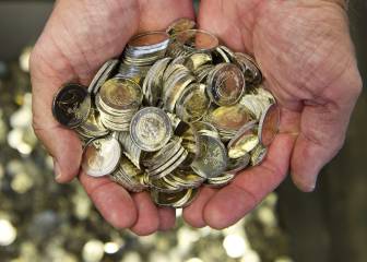 Un hombre sostiene varias monedas de euro.