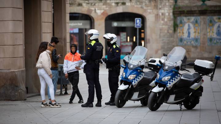 Policías y ciudadanos durante el estado de alarma, en Barcelona.