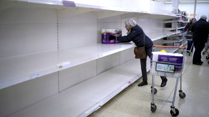 Una señora coge el último paquete de papel higiénico de un lineal vacío en un supermercado de Northwich (Reino Unido) duante la crisis del coronavirus.