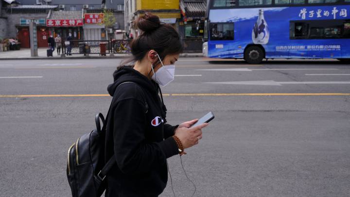 Chica china camina con su móvil en Pekín.