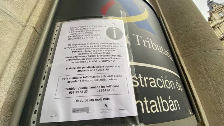 Un aviso en la entrada de la delegación tributaria de Montalbán, en Madrid, informa a los contribuyentes de que la oficina de Hacienda está cerrada por la pandemia del coronavirus COVID-19.