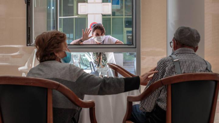 Una persona conversa con sus padres a través de una ventana habilitada 