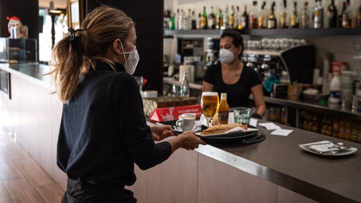Una camarera recoge una bandeja en Girona. 