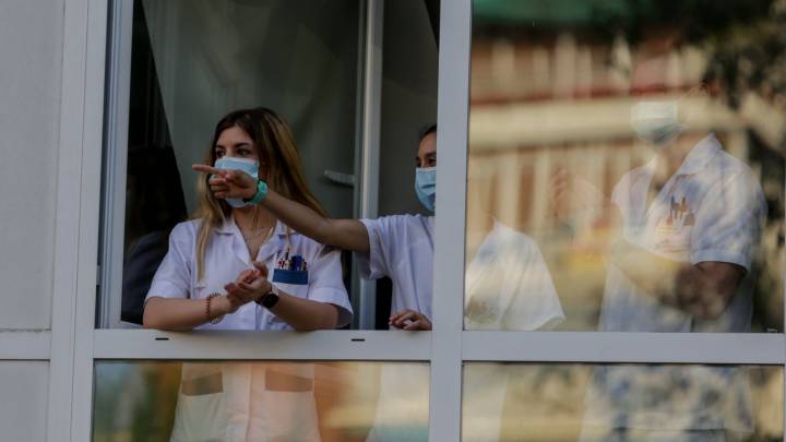 Sanitarios aplauden desde una ventana de del Hospital Fundación Jiménez Díaz.
