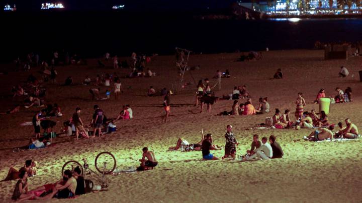 Varios jóvenes se divierten en la playa de la Barceloneta, en Barcelona, anoche, tras el cierre de discotecas decretado por las autoridades catalanas 