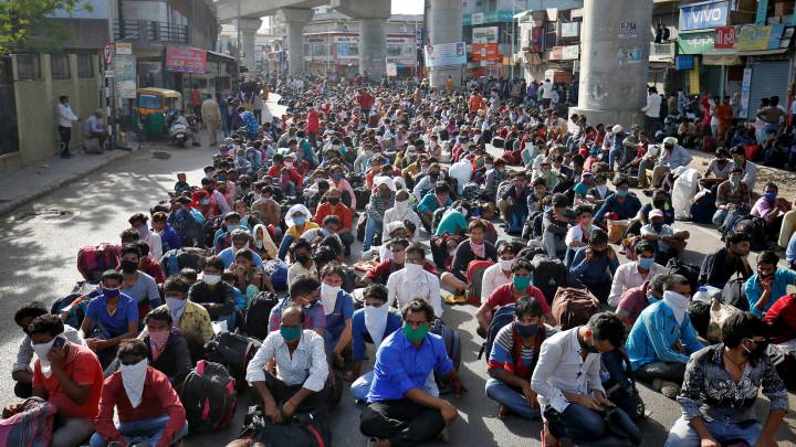 Imagen de varios trabajadores y sus familias mientras esperan la llegada del tren en Uttar Pradesh.