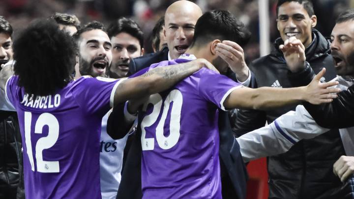 Real Madrid's Marco Asensio celebrates with players and manager.