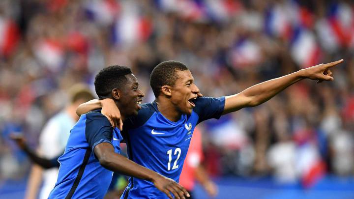 Ten-man France swept England aside at the Stade de France, with goals from Umtiti, Sidibé, and Dembélé as Varane saw red. Kane scored twice for England.
