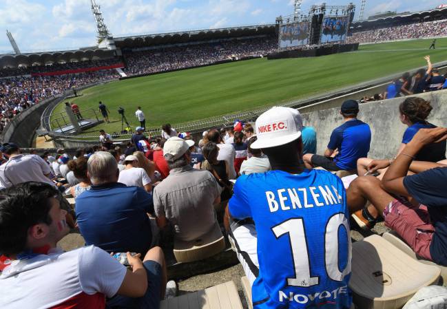 A France supporter wears a shirt bearing the name of Karim Benzema, as people gather to watch the Russia 2018 World Cup final football match between France and Croatia, on July 15, 2018 in a stadium in Bordeaux.