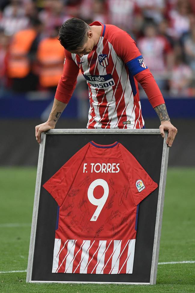 Emotional | Atletico Madrid's Fernando Torres reacts as he receives a framed jersey signed by teammates.
