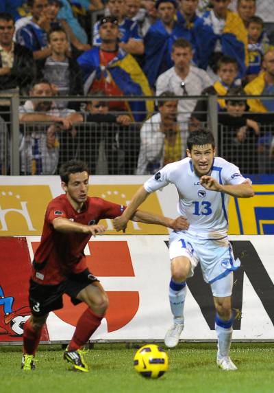 El bosnio Mujdza y el albanés Vangjeli corren hacia el balón.