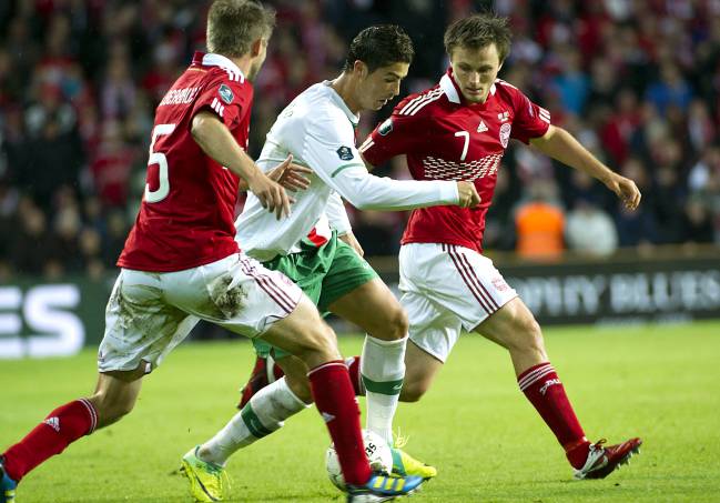 Cristiano Ronalo trata de controlar el balón ante los daneses Silberbauer yJorgensen.