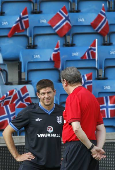 Hodgson hablando con el capitán inglés Steven Gerrard.