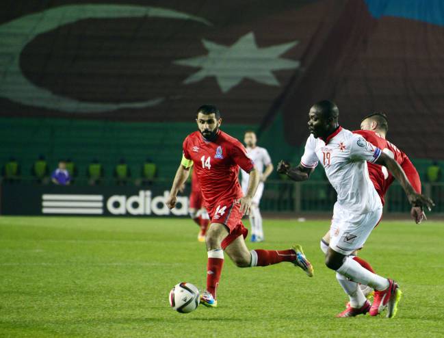 El jugador de Azerbaiyán Sadygov y el maltés Effiong persiguen el esférico.