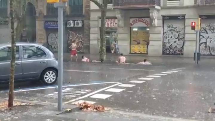 Cuatro chicos 'nadan' en la calle tras las lluvias en Barcelona