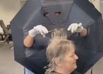 Una peluquera hace agujeros en un paraguas para poner una 'barrera' con sus clientes