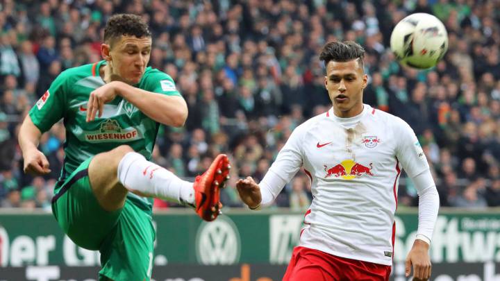 Milos Vljkovic, del Werder Bremen, golpea el balón ante la presencia de Davie Selke, del Red Bull Leipzig.