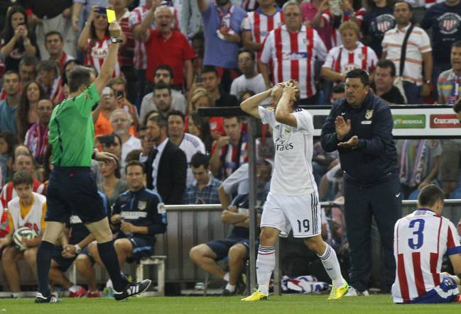 Fernández Borbalán muestra a Modric una de las dos amarillas que vio contra el Atlético en la vuelta de la Supercopa de España de 2014.
