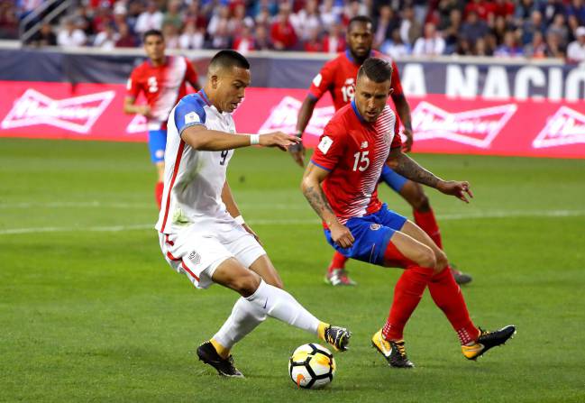 El estadounidense Bobby Wood protege el balón ante el costarricense Francisco Calvo.