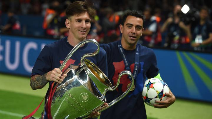 Messi y Xavi celebran con el trofeo de la Champions que conquistó el Barcelona en 2015 contra la Juventus en el Estadio Olímpico de Berlín.