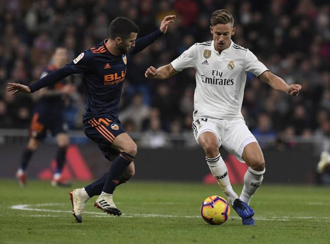 Gayá intenta frentar el avance de Marcos Llorente en el Real Madrid-Valencia.