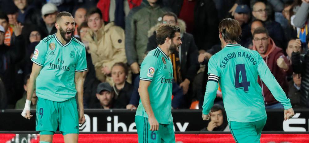 Benzema celebra su gol con Nacho y Ramos.