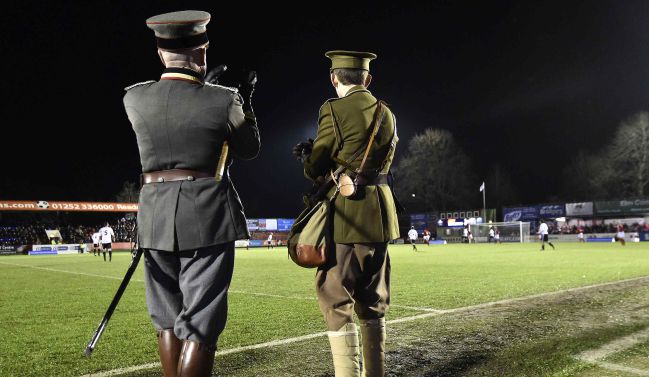 Dos militares, vistiendo una réplica de los uniformes de la Primera Guerra Mundial, siguen el partido del centenario, en Aldershot.