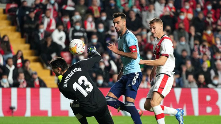 Brais Méndez pica el balón por encima de Stole Dimitrievski y ante la mirada de Nikola Maras durante el partido entre el Rayo Vallecano y el Celta.