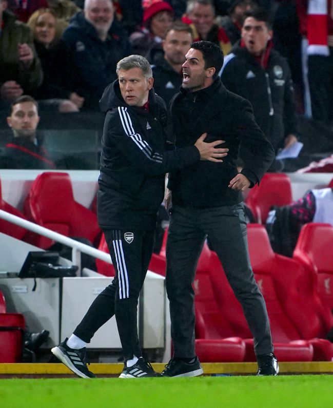Mikel Arteta, entrenador del Arsenal, es frenado por un miembro de su cuerpo técnico.