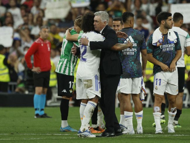 Marcelo y Ancelotti se abrazan sobre el césped del Bernabéu.