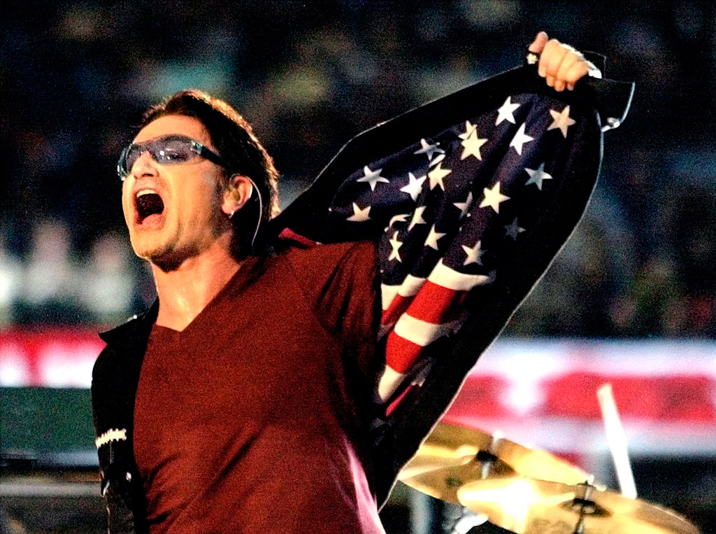 Bono, cantante de U2, muestra la bandera estadounidense en el interior de su chaqueta