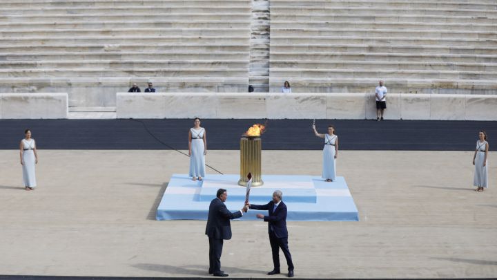 El presidente del Comité Olímpico Griego Spyros Capralos entrega la antorcha olímpica al vicepresidente del comité organizador de los Juegos Olímpicos de Invierno de Pekín 2022 y vicepresidente del Comité Olímpico Internacional Yu Zaiqing.