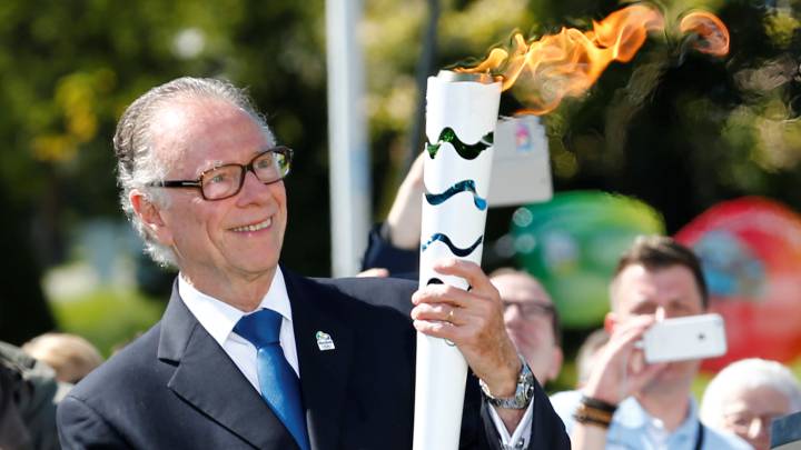 Carlos Arthur Nuzman, presidente del Comité Organizador de Rio 2016, posa con la antorcha olímpica.