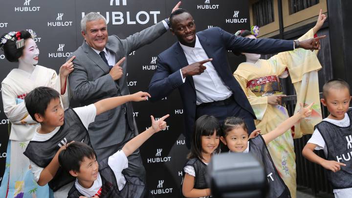 Usain Bolt hace su gesto típico del rayo junto a unos niños durante un acto de la marca de relojes HUBLOT en Kyoto, Japón.