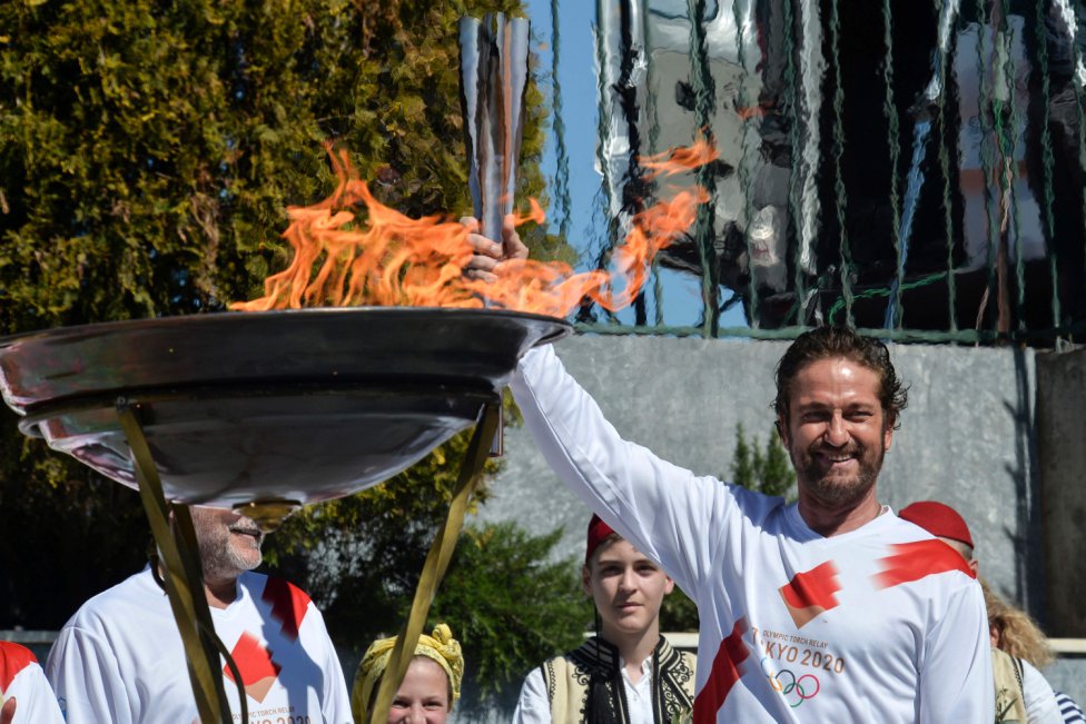 El actor estadounidense Gerard Butler posa con la llama olímpica durante el relevo en Esparta antes de los Juegos Olímpicos de Tokio 2020.