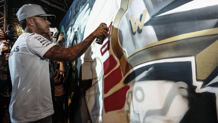 Lewis Hamilton pintando un casco en un acto en Brasil.