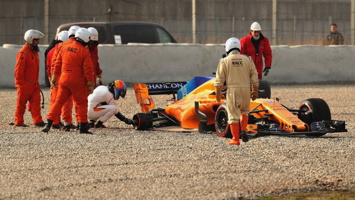 Fernando Alonso inspeccionando la llanta del McLaren que perdió la rueda.