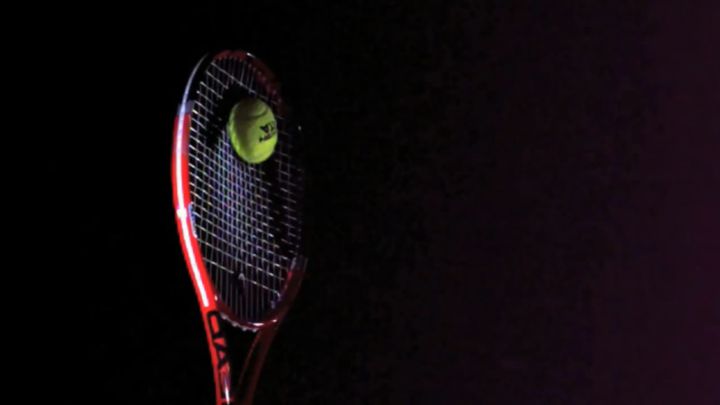 raqueta impactando una pelota de tenis en camara lenta