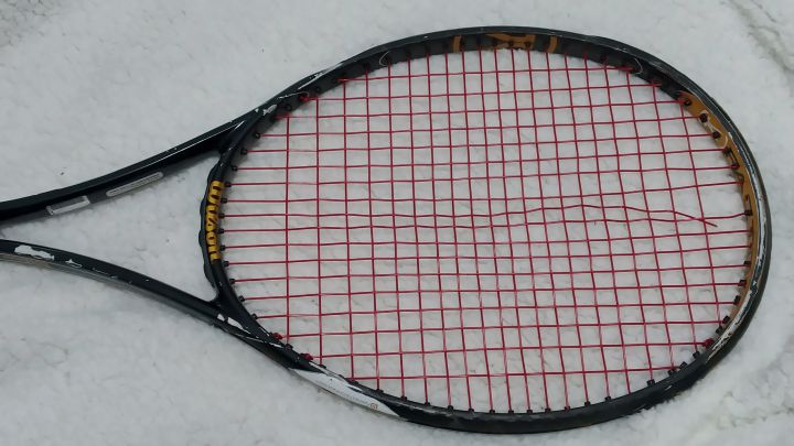 raqueta de tenis con cuerdas rotas