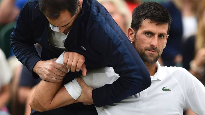 Djokovic, atendido por el fisio de Wimbledon.
