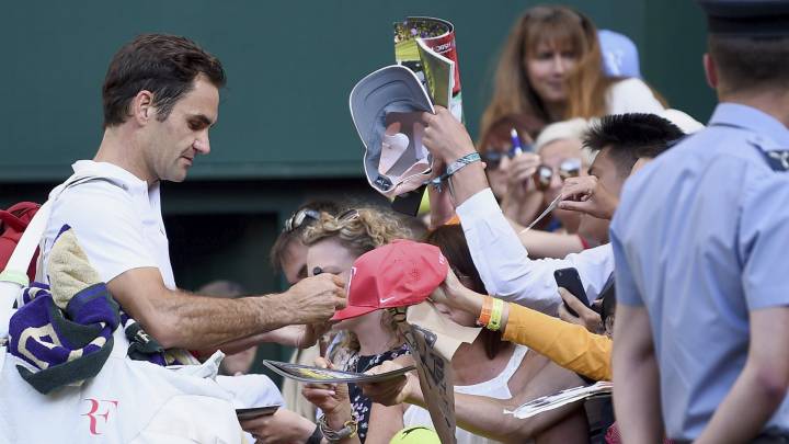Roger Federer firma autógrafos en Wimbledon.