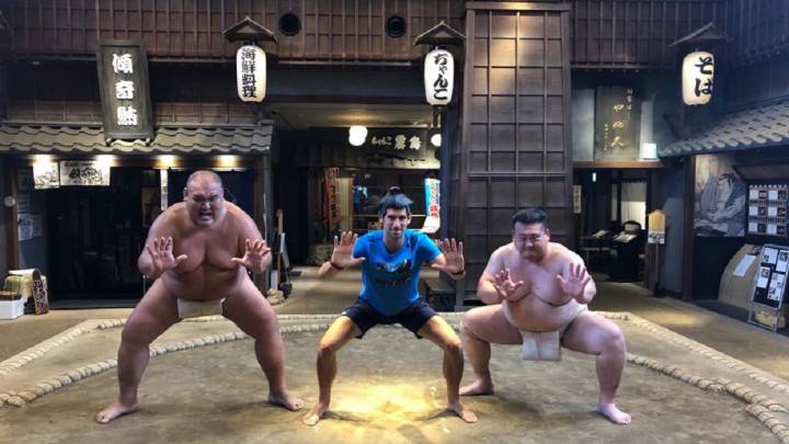 Novak Djokovic posa junto a dos luchadores de sumo antes de competir en el Rakuten Japan Open de Tokio.