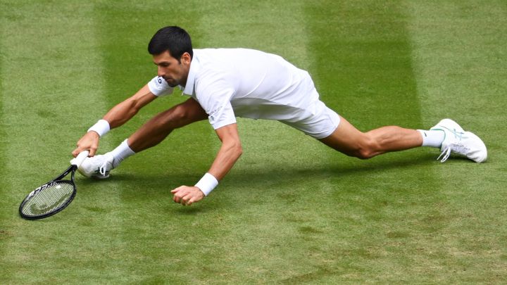 Novak Djokovic tries to return a ball during his match against Kevin Anderson at Wimbledon 2021.