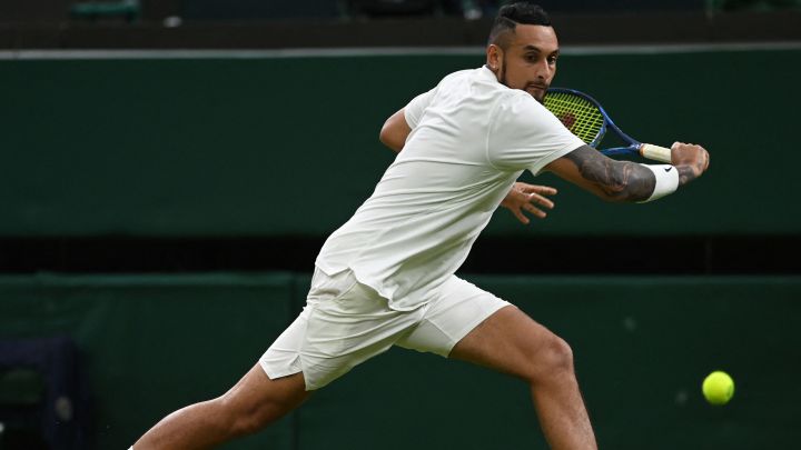 Australian tennis player Nick Kyrgios returns a ball during his match against Ugo Humbert in the 2021 Wimbledon tournament.