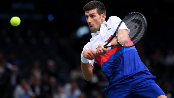 Novak Djokovic devuelve una bola durante su partido ante Marton Fucsovics en el Rolex Paris Masters, el Masters 1.000 de París, en el AccorHotels Arena de París.