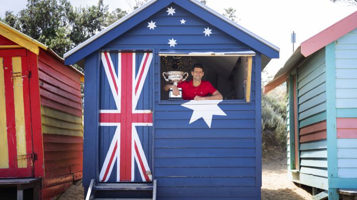 Novak Djokovic poses before the media with the 2021 Australian Open champion trophy.