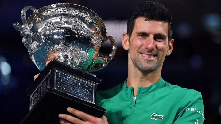 Serbian tennis player Novak Djokovic poses with the Norman Brookes trophy after defeating Daniil Medvedev in the 2021 Australian Open final.