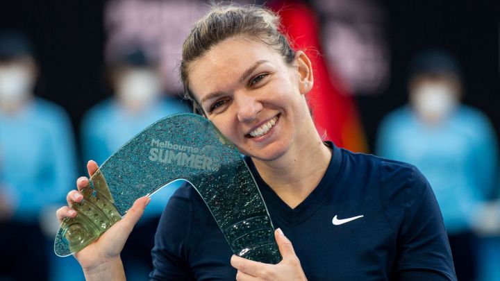 Simona Halep of Romania celebrates with the trophy after winning her women's singles match against Veronika Kudermetova of Russia at the Melbourne Summer Set tennis tournament in Melbourne on January 9, 2022. (Photo by Mike FREY / AFP) / -- IMAGE RESTRICTED TO EDITORIAL USE - STRICTLY NO COMMERCIAL USE --